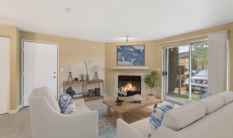 a living room with couches and a fireplace     and a door